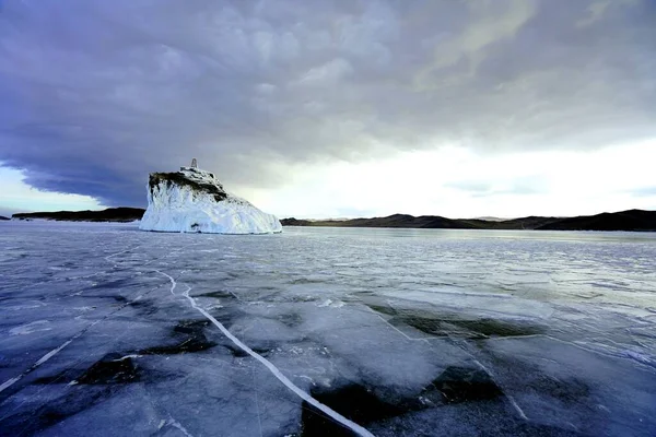 湖冰因裂缝而有质感 湖中的岛屿被冰雪环绕着 — 图库照片