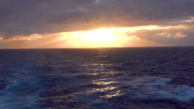 Güneş ışığı zaman zaman bulutlar arasında belirdi ve kayboldu. Sis çok göz kamaştırıcı. Tekneden görünen gün batımı. Kuzey Pasifik Okyanusu, Haziran 2019.