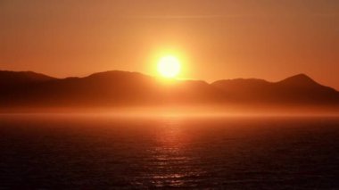 Gölün üzerinde güzel altın gün batımı. Dağların önünde turuncu ışık. Ketchikan, Alaska gerçekten 