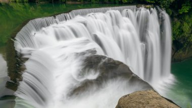 Turkuaz dereler, yeşil çalılar, şelale manzarası. Doğal manzarayı canlandırıyor. Tayvan