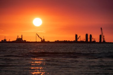 Sahil boyunca inşaat halindeki bir rıhtım. Alacakaranlık İskelesi inşaatının silueti. Tiwan