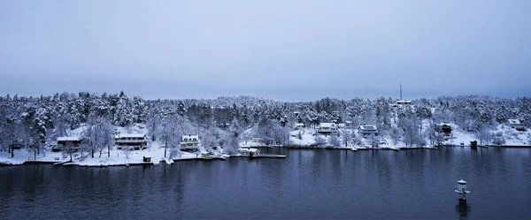 Rocky island in the Swedish fjords on the way to Stockholm. A winter snow scene on a cruise from Finland to Stockholm.