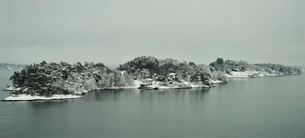 Rocky island in the Swedish fjords on the way to Stockholm. A winter snow scene on a cruise from Finland to Stockholm.