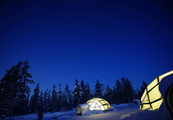 Geceleri karda cam bir eskimo kulübesi. Kuzey Işıkları 'nı görmek için camdan bir ev. Finlandiya