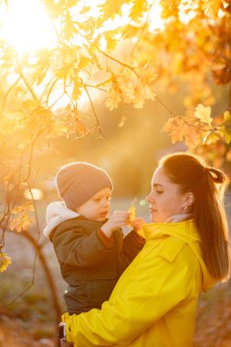 Sonbaharda annesiyle birlikte yaprakların arasında.
