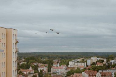 Olsztyn, Polonya 5 Nisan 2022 - Şehrin ortasında binalar arasında uçan askeri helikopterler.