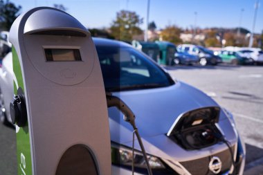 PAMPLONA, NAVARRA SPAIN 13 HAZİRAN 2022: Şarj istasyonunun yanındaki elektrikli araba şarj ediliyor