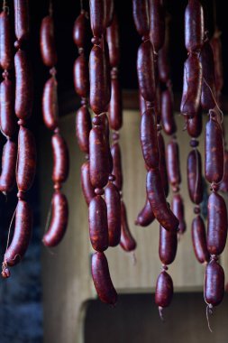 Domuz eti ve kurutulmuş taze sosisler. Odun dumanı ve havayla asılmış..