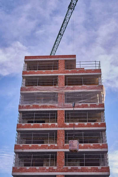 Views of a crane working on the lifting of materials during the construction of a social protection house Royalty Free Stock Photos