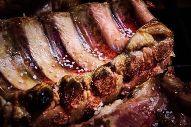 Sulu sığır kaburgası ve domuz kaburgası ızgaranın üstünde yavaşça pişiriliyor.