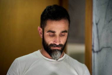 Yüzünü yıkamak, sakal tıraş etmek ya da diş fırçalamak için aynanın önünde duran genç bir adam. Yüksek kalite fotoğraf