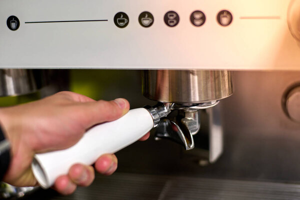 Hand squeezing to make coffee in automatic coffee maker. High quality photo