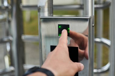 Hand pressing a fingerprint reader to open a security door. High quality photo