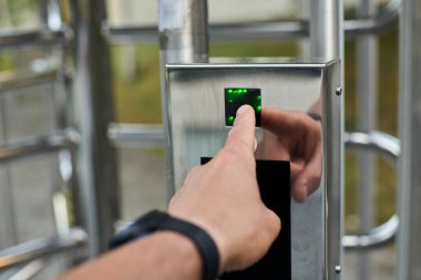 Hand pressing a fingerprint reader to open a security door. High quality photo