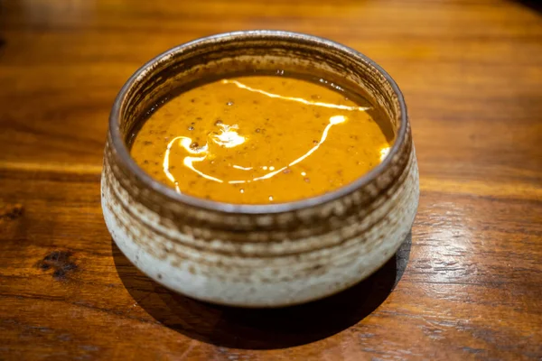 Bir kase lezzetli dal Makhani, Hint mercimek ve ahşap masada krema.