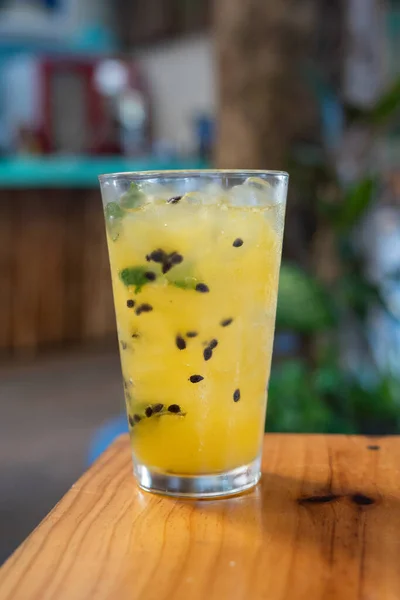 Bir tutku meyveli mojito kokteyli yakın plan. Masada nane ve buz var.