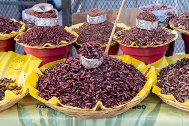 Oaxaca 'dan taze kızarmış ve tuzlanmış çekirgeler (çeviri: chapulines) yatay bir masada sergilenmektedir.