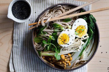 Çizgili peçete üzerinde haşlanmış yumurtalı taze Japon ramen çorbası, yatay.