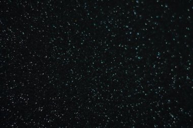 Siyah arkaplanda uçan toz parçacıkları