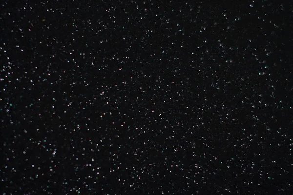 Siyah arkaplanda uçan toz parçacıkları