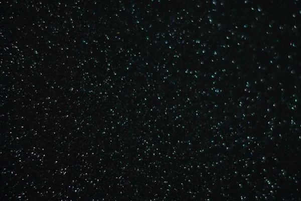 Siyah arkaplanda uçan toz parçacıkları