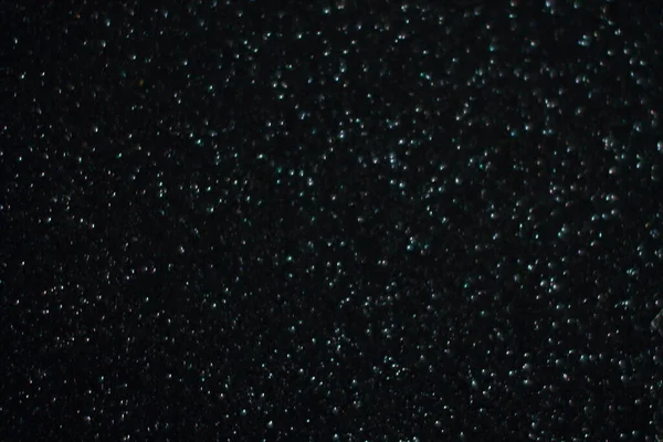 Siyah arkaplanda uçan toz parçacıkları