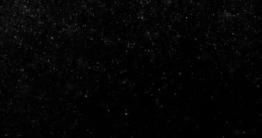 Siyah zemin üzerinde rastgele uçan küçük beyaz parçacıklara sahip video