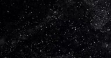 Siyah zemin üzerinde rastgele uçan küçük beyaz parçacıklara sahip video