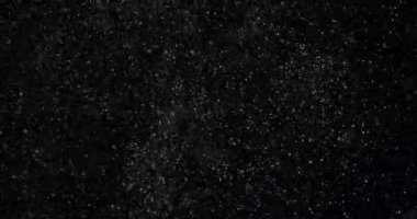 Siyah zemin üzerinde rastgele uçan küçük beyaz parçacıklara sahip video