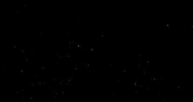 Siyah zemin üzerinde rastgele uçan küçük beyaz parçacıklara sahip video