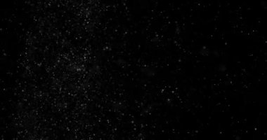 Siyah zemin üzerinde rastgele uçan küçük beyaz parçacıklara sahip video