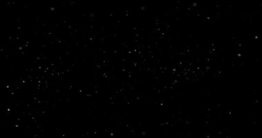 Animation with small white particles flying randomly on black background