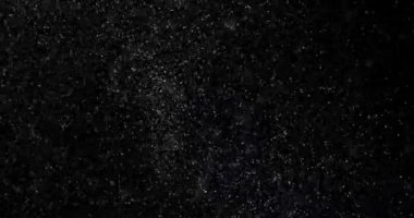 Siyah zemin üzerinde rastgele uçan küçük beyaz parçacıklara sahip video