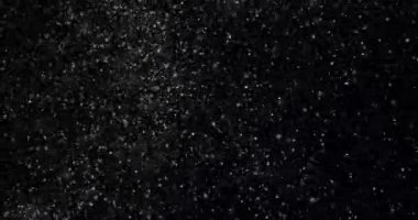 Siyah zemin üzerinde rastgele uçan küçük beyaz parçacıklara sahip video