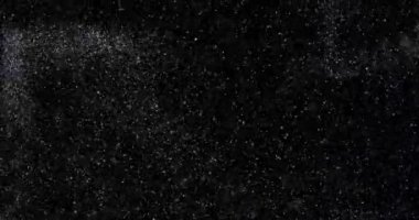 Siyah zemin üzerinde rastgele uçan küçük beyaz parçacıklara sahip video