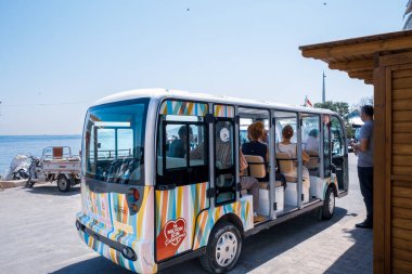 Kinaliada, İstanbul, Türkiye - 07.30. 2021: Ada taşımacılık turu minibüsünün dikiz görüntüsü tartışmaların ardından at arabasıyla değişti ve insanlar seyahat için sırada bekliyorlar