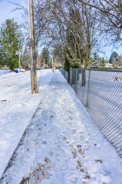 Burien, Washington 'da karla kaplı bir çit ve kaldırım manzarası.