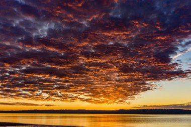Washington 'da gün batımında Puget Sound' un üzerinde bir bulut tabakası süzülüyor..