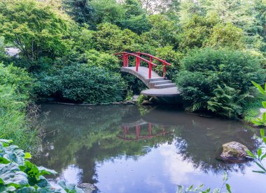 A red walking bridge in a garden in Renton, Washington.