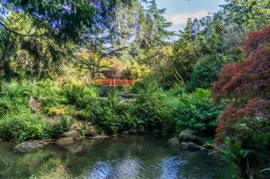A red walking bridge in a garden in Seattle, Washington.