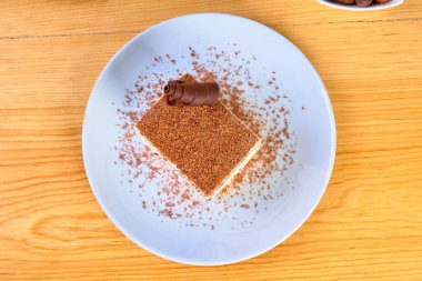 İtalyan yarı freddosu (viennetta) vanilya kremalı ve çikolatalı tatlı, çikolata tozuyla süslenmiş ve mavi bir tabakta servis edilmiş. en üstteki görünüm