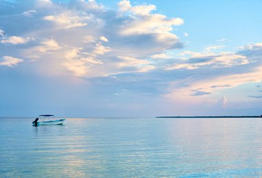 Holbox, Meksika sahilinde bir tekne. Maya Riviera manzarası. Mavi ve mor tonlu bulutlarla dolu muhteşem bir gökyüzü..