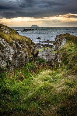 Turnberry Point deniz fenerinin yanında kayalık deniz manzaralı karamsar gökyüzü..