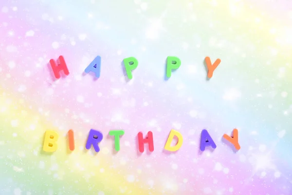 Photograph of some magnet letters with the English text of Happy Birthday on a colored cardboard background.The photograph is taken in horizontal format and from an overhead point of view. — Stockfoto