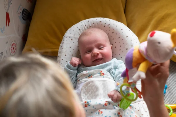 Two month baby on the bed looking on a beanbag toy — Stock Photo, Image