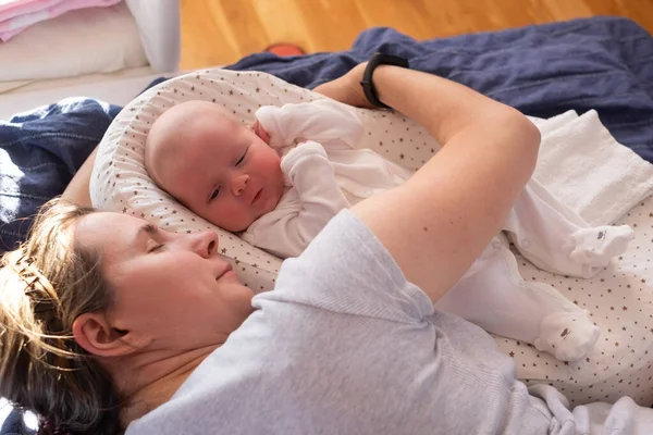 Close up retrato de mãe com um bebê descansando na cama — Fotografia de Stock