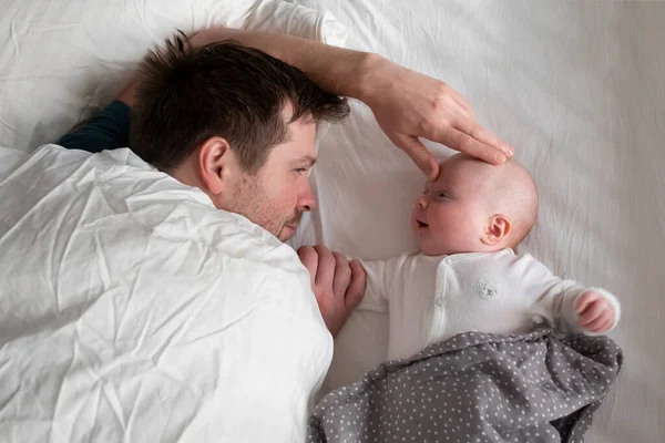 Sleeping father and cute child resting together in bed. — Stock Photo, Image