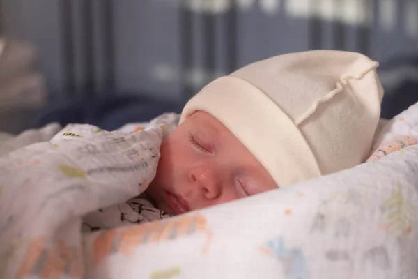 Bebé durmiendo en la cama con una manta. — Foto de Stock