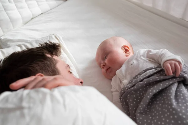 Sleeping father and cute child resting together in bed. — Stock Photo, Image