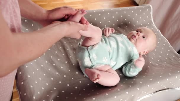 Mãe massageando suas pernas de bebê, fazendo exercícios para músculos — Vídeo de Stock